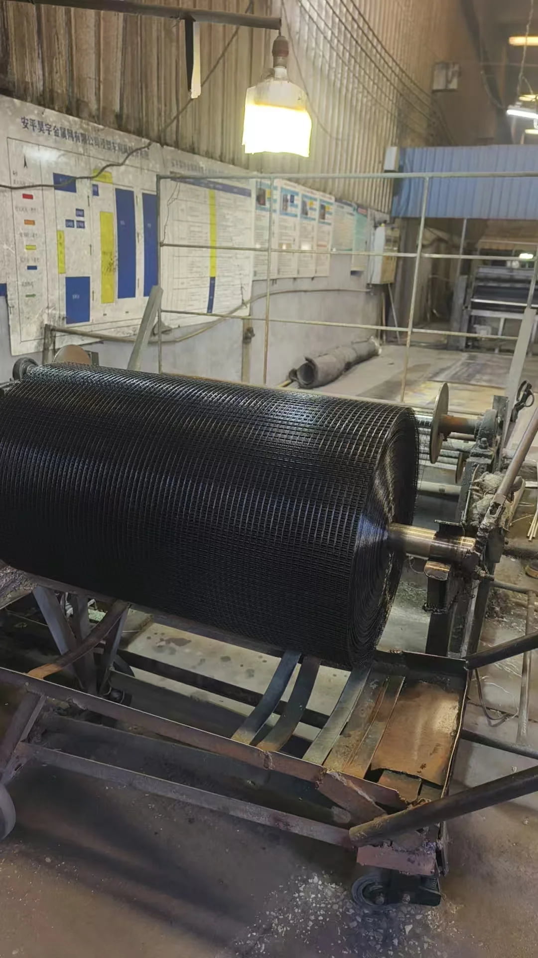 Workers inspecting PVC coated welded wire mesh quality in workshop